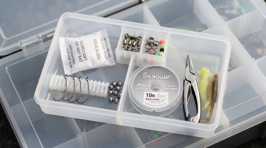 Organized tackle box with fishing hooks, weights, line, and tools.