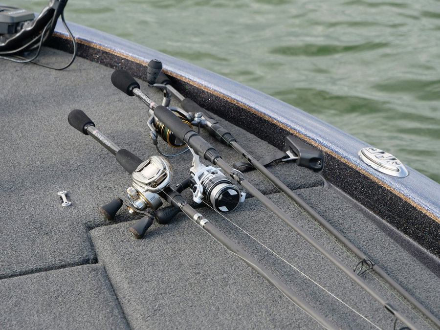 Spinning and baitcasting reels placed on a boat deck.